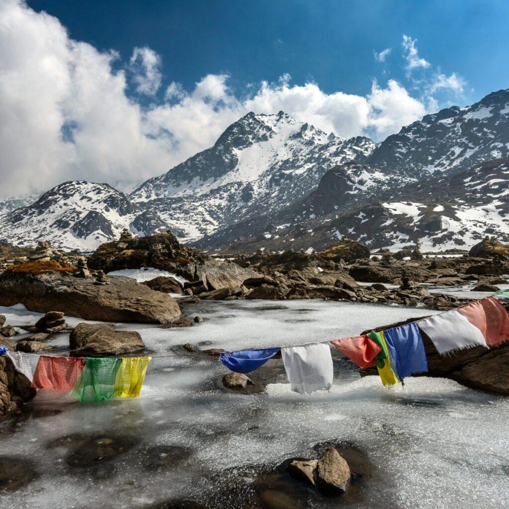 Snow-capped peaks of the Himalayas with colorful prayer flags in the foreground.