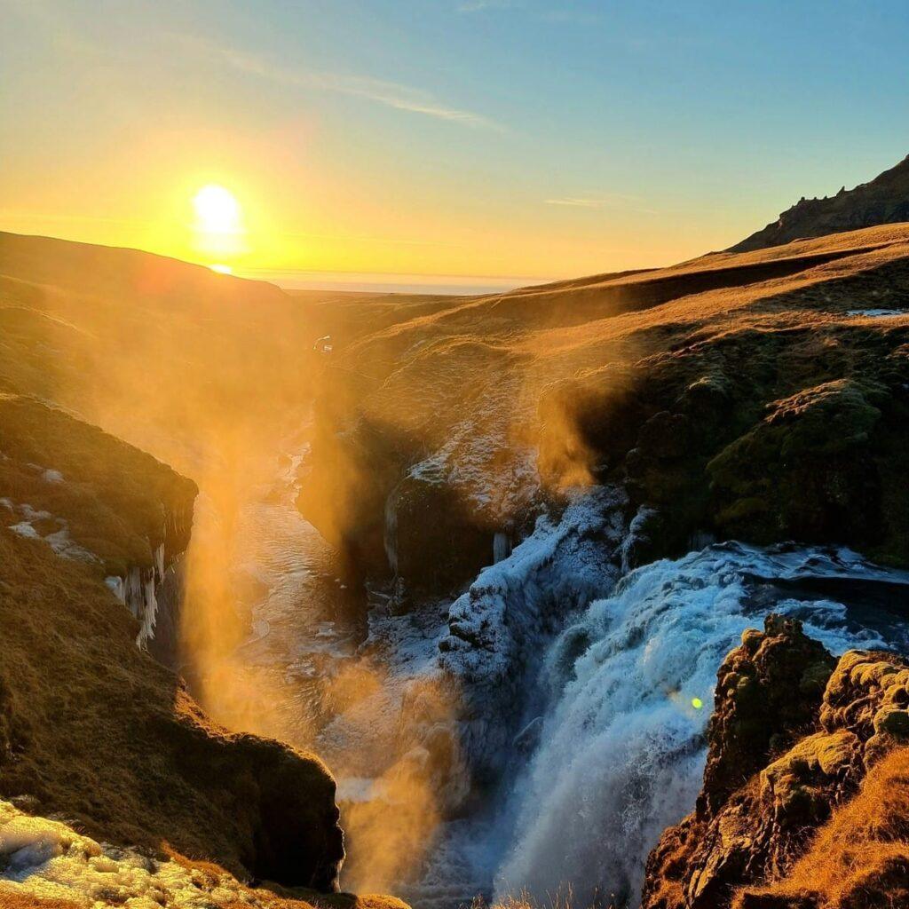 Sunset over a waterfall and canyon in Iceland